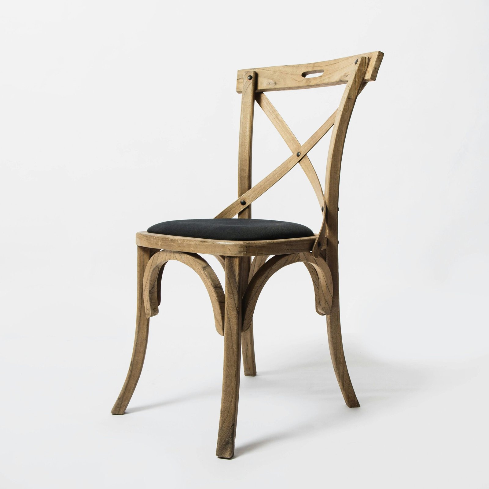 Side view of a stylish rustic wooden chair with a black cushion against a white background.